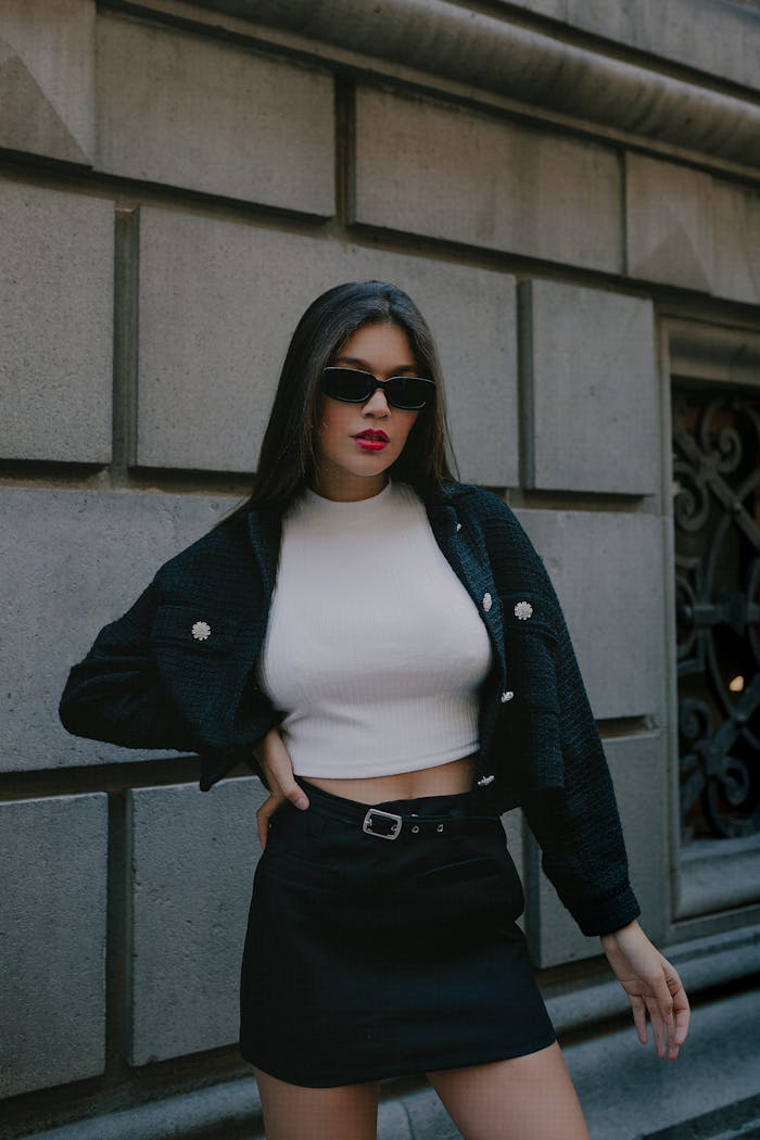Stylish young woman with sunglasses and long hair posing outdoors in Mexico City.